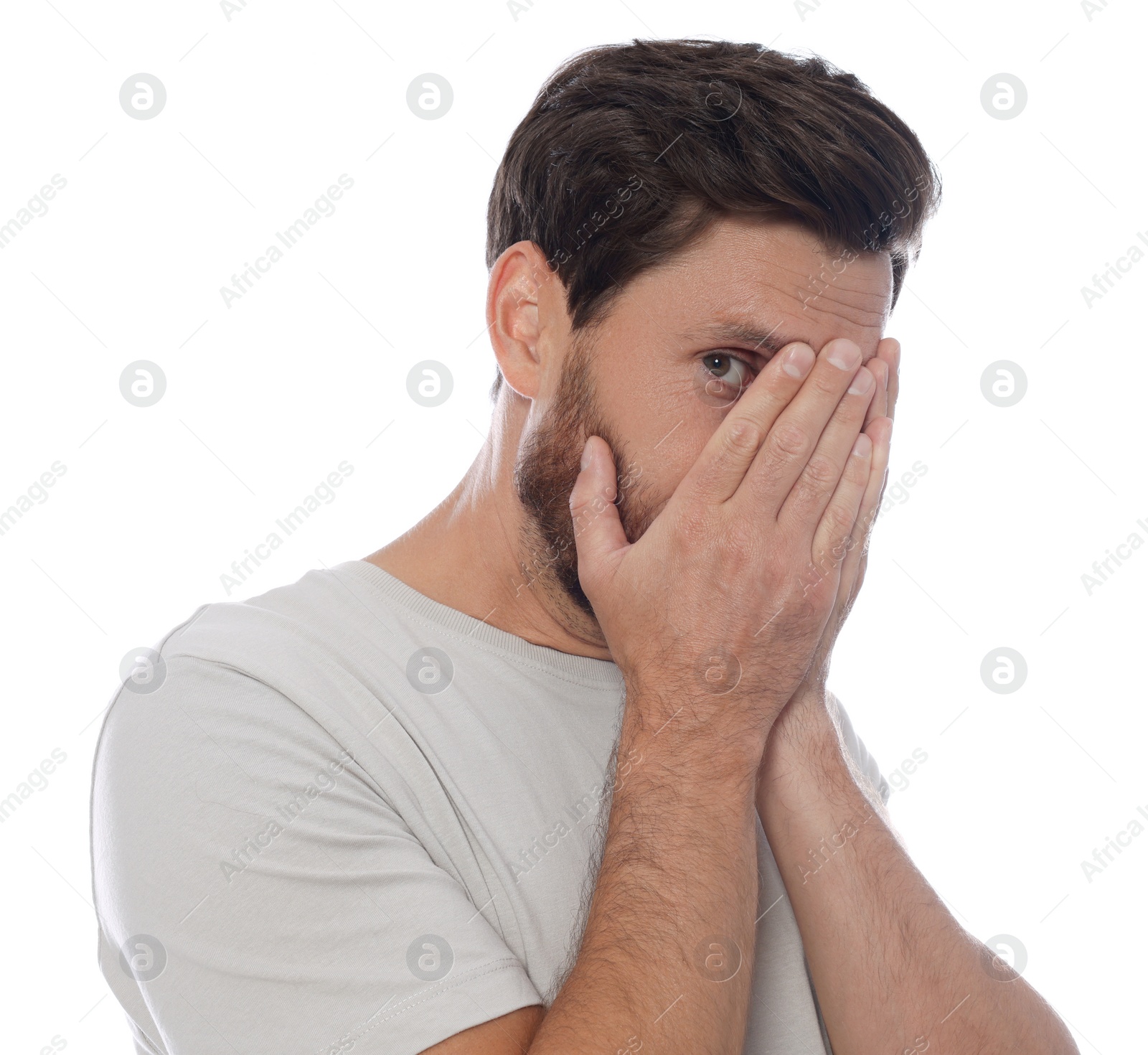 Photo of Embarrassed man covering face with hands on white background