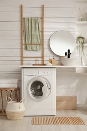 Stylish bathroom interior with modern washing machine