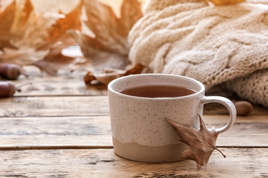 Photo of Composition with cup of hot cozy drink and autumn leaves on windowsill. Space for text