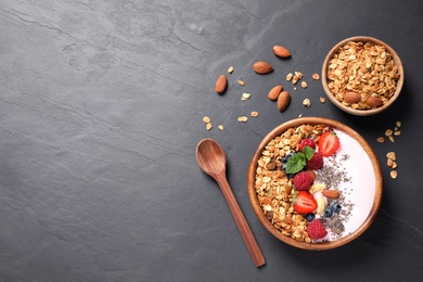 Photo of Healthy homemade granola with yogurt on dark grey table, flat lay. Space for text