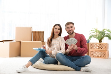 Beautiful young couple with money at home