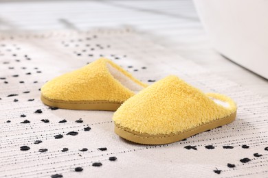 Yellow soft slippers on carpet at home, closeup