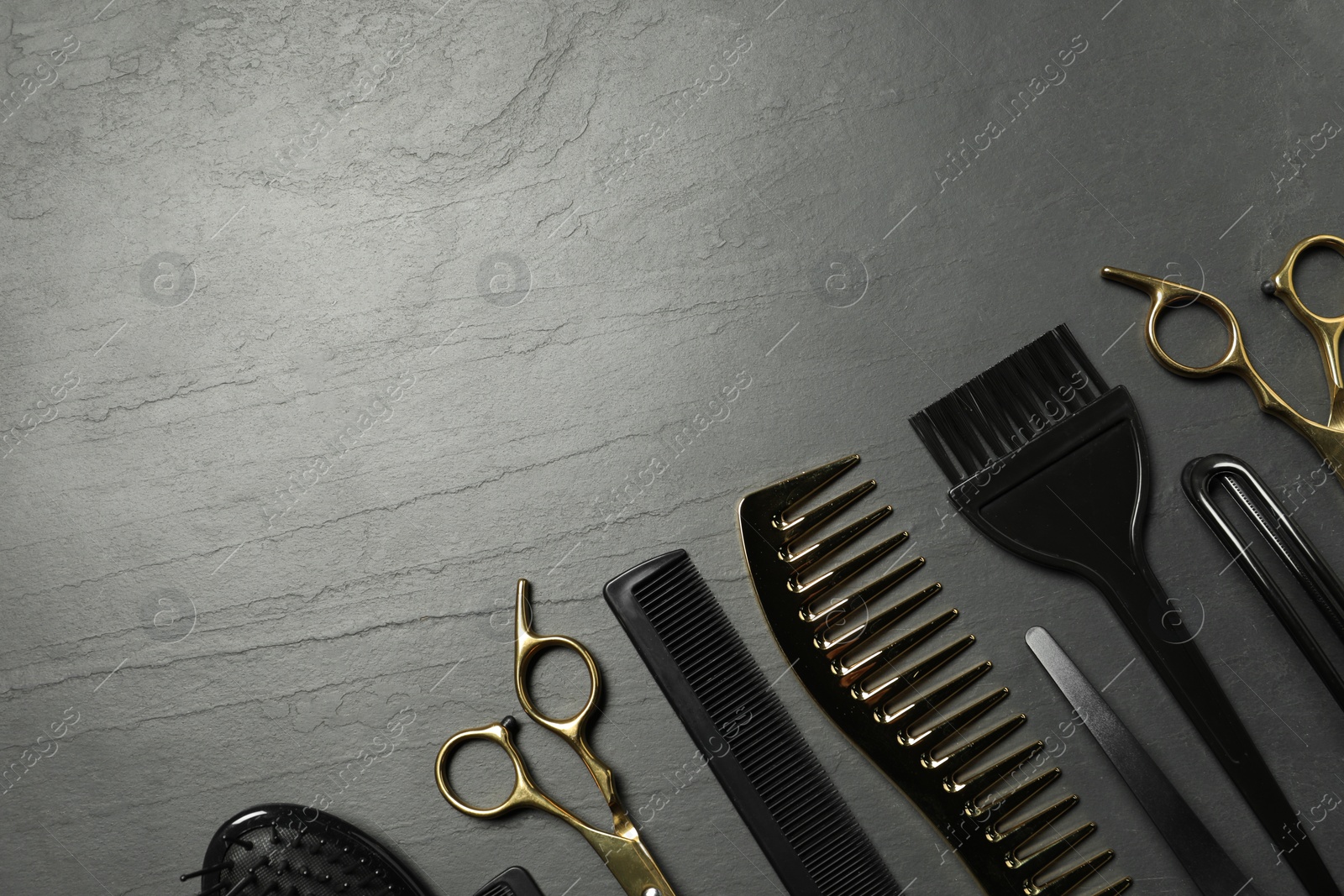 Photo of Hairdressing tools on grey textured background, flat lay. Space for text