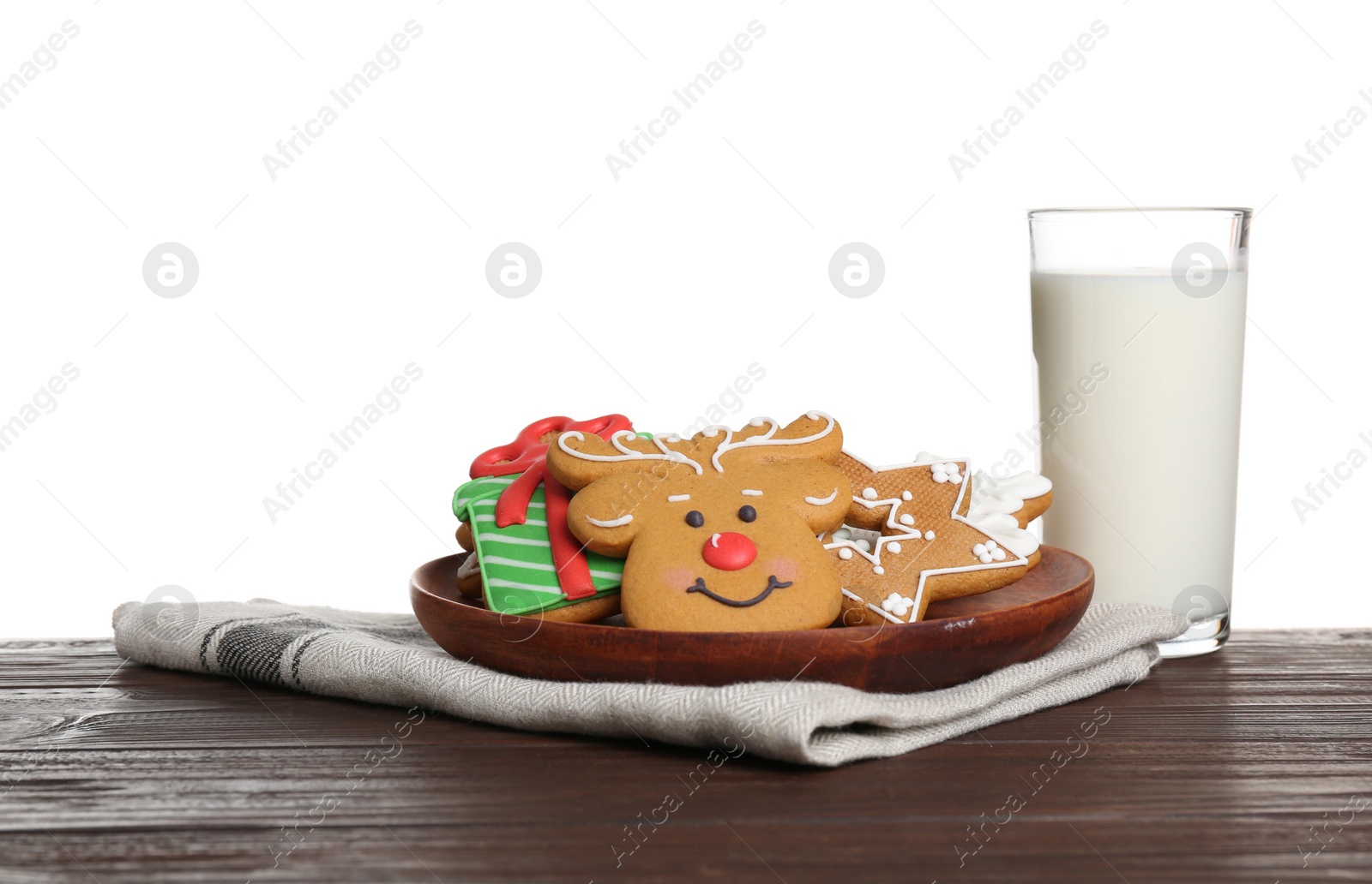 Photo of Plate with tasty Christmas cookies near glass of milk on table against white background