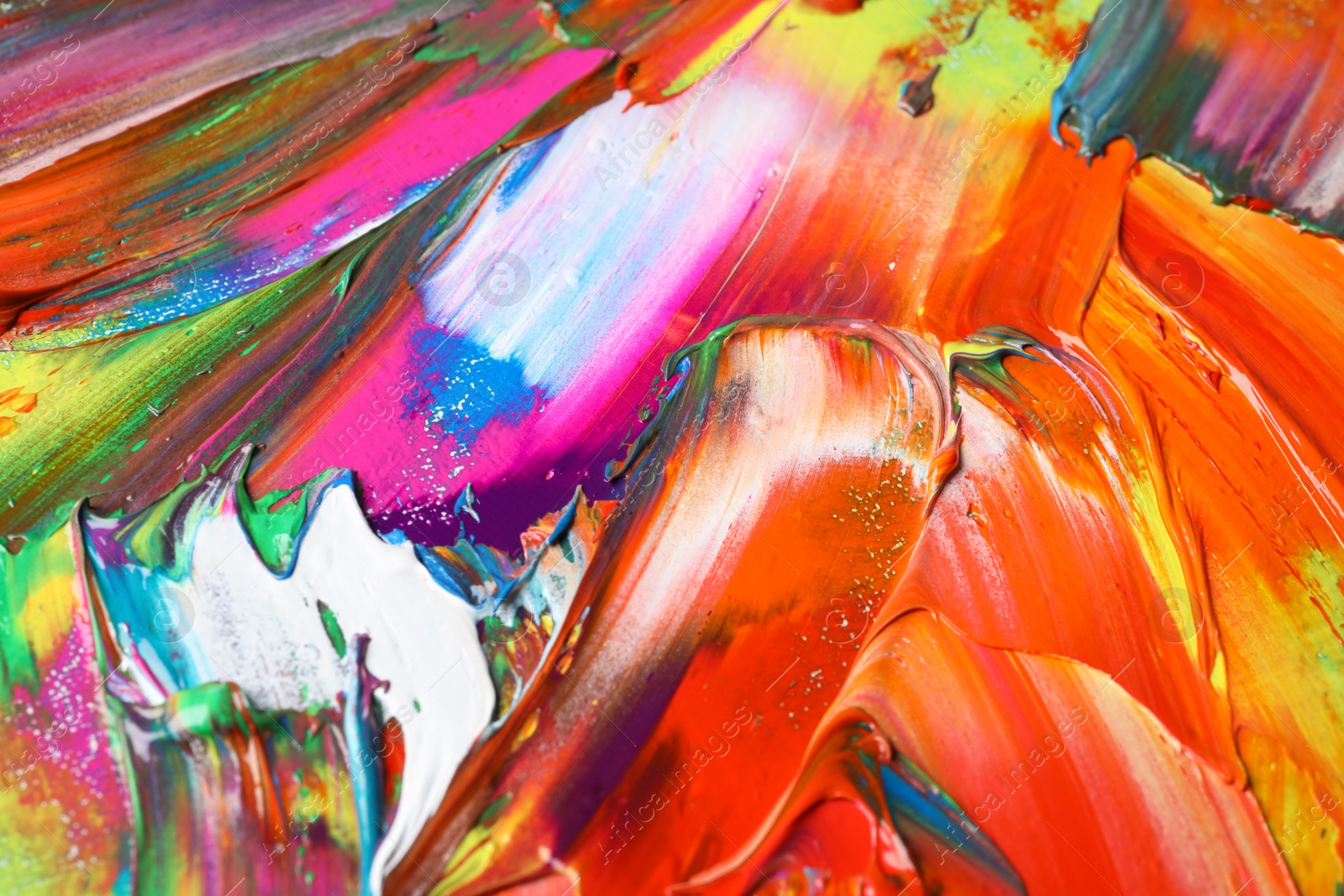 Photo of Strokes of colorful acrylic paints as background, closeup view