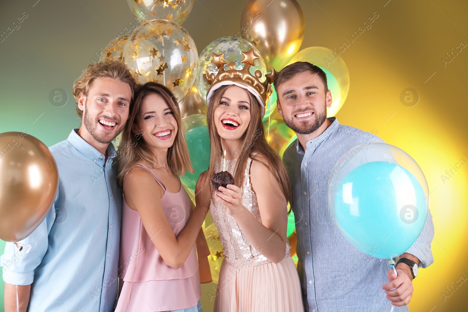 Photo of Friends with air balloons and muffin on color background. Birthday celebration