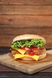 Photo of Delicious burger with tofu, fresh vegetables and sauce on wooden table