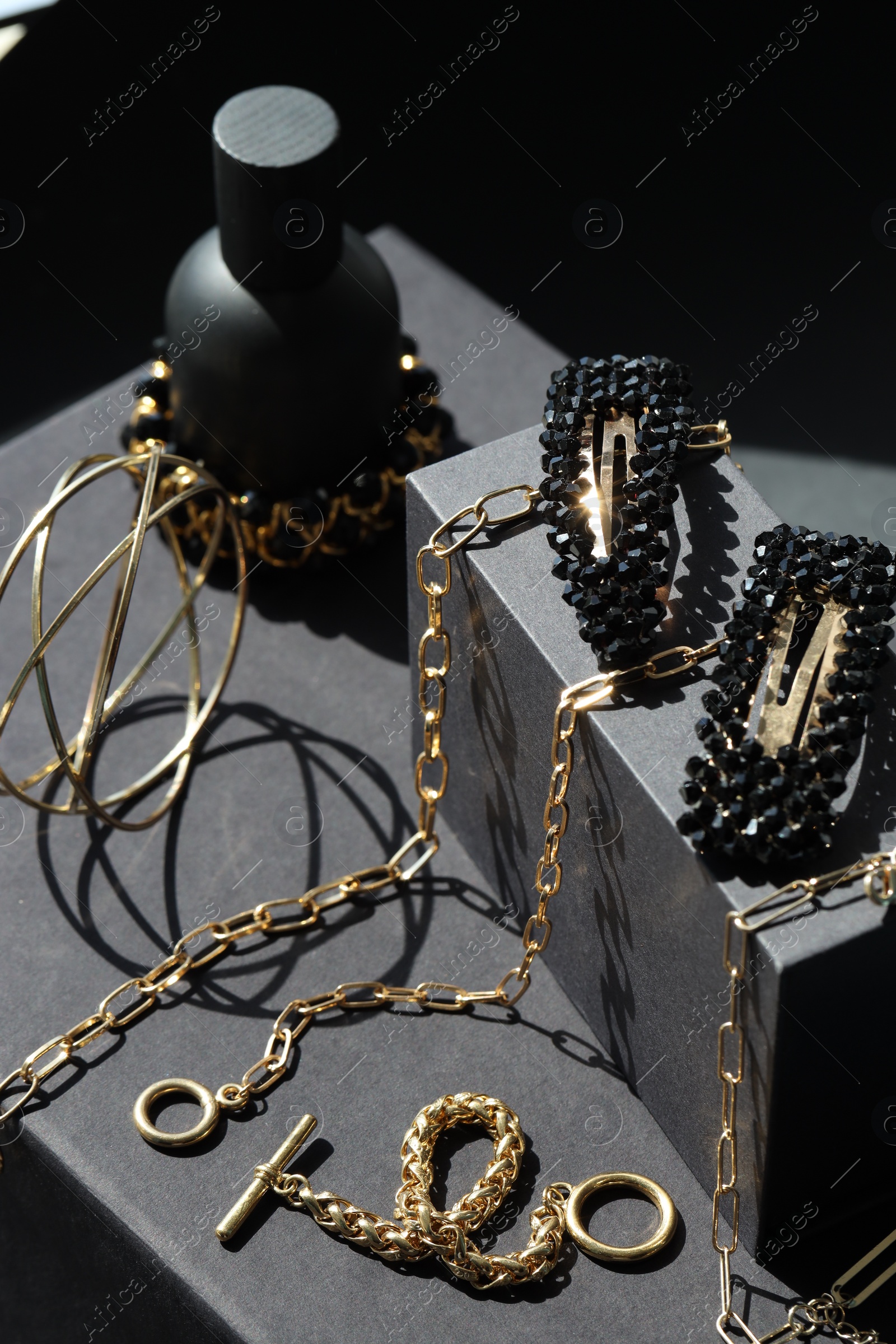 Photo of Presentation of metal chains and other different accessories on black table. Luxury jewelry