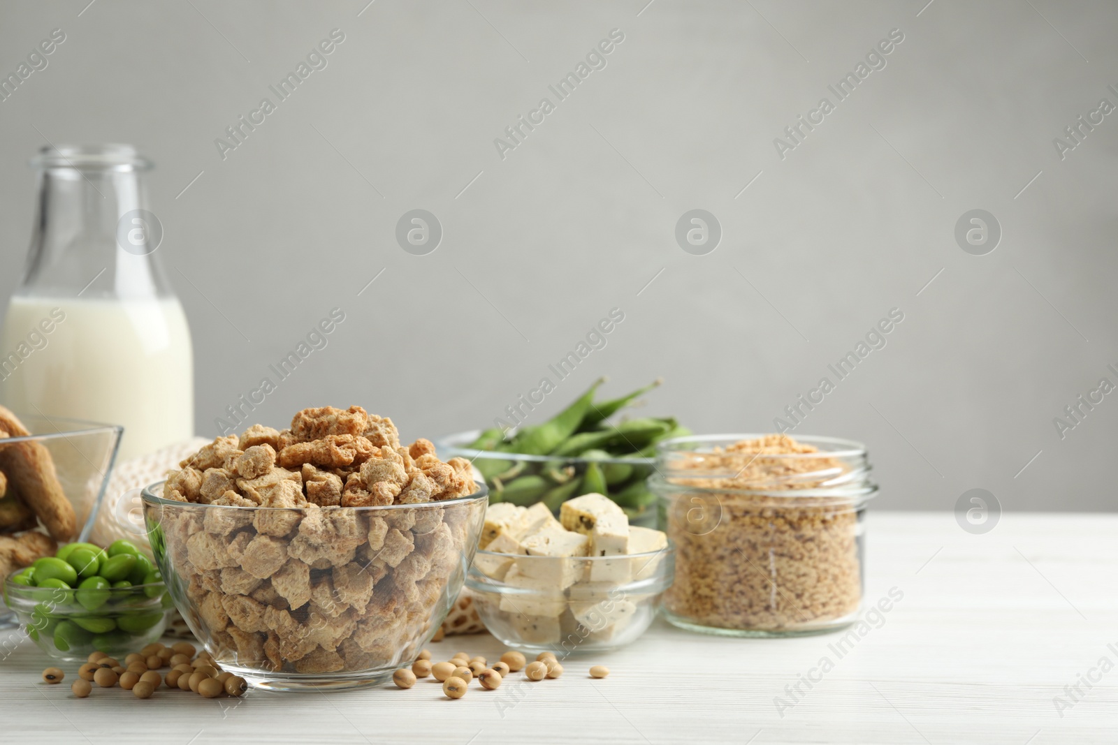 Photo of Different organic soy products on white wooden table, space for text