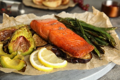 Tasty cooked salmon and vegetables served on grey table, closeup. Healthy meals from air fryer
