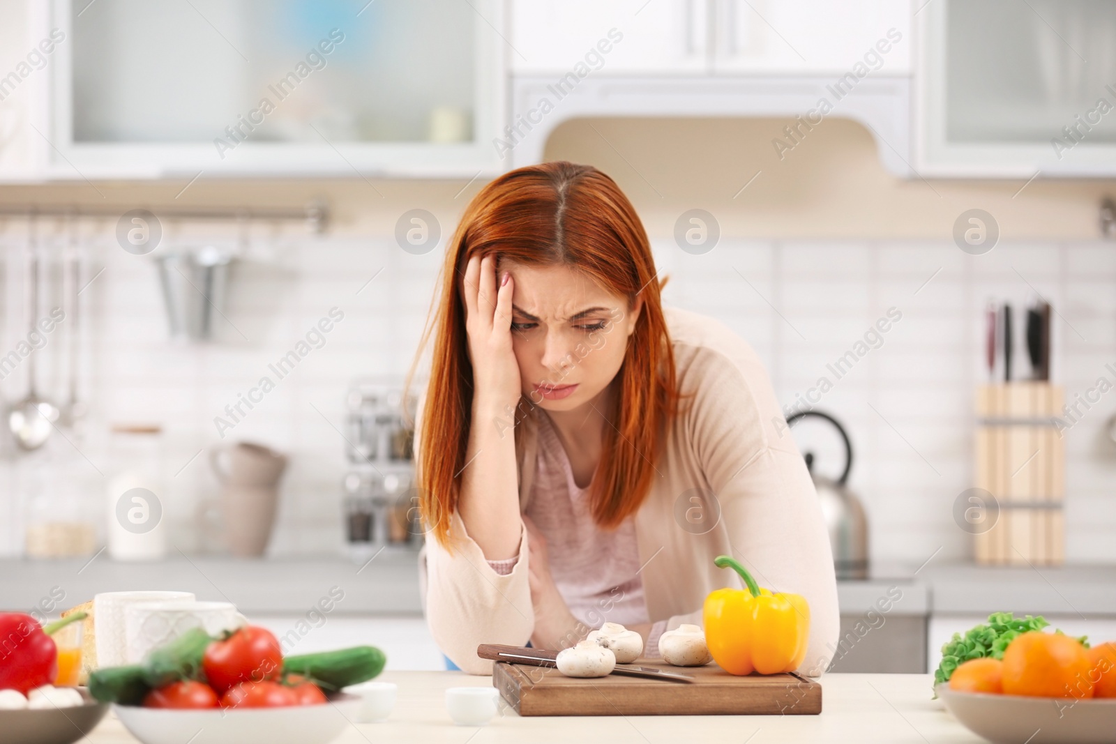 Photo of Tired housewife cooking in kitchen