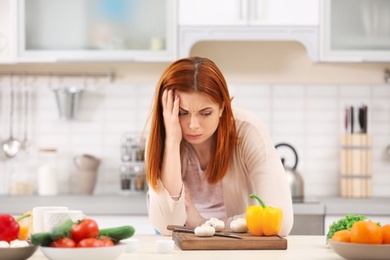 Photo of Tired housewife cooking in kitchen