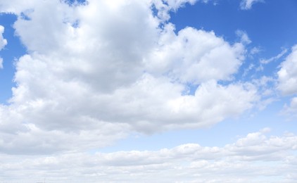 Photo of Picturesque view of beautiful fluffy clouds in light blue sky above field