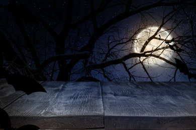 Image of Wooden surface and bats flying in night sky with full moon. Halloween illustration