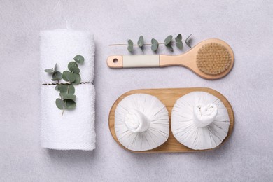 Flat lay composition with spa products and eucalyptus branches on grey table