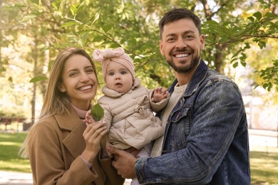 Photo of Happy parents with their baby in park on sunny day