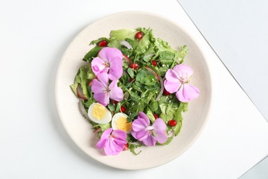 Fresh spring salad with flowers isolated on white, top view
