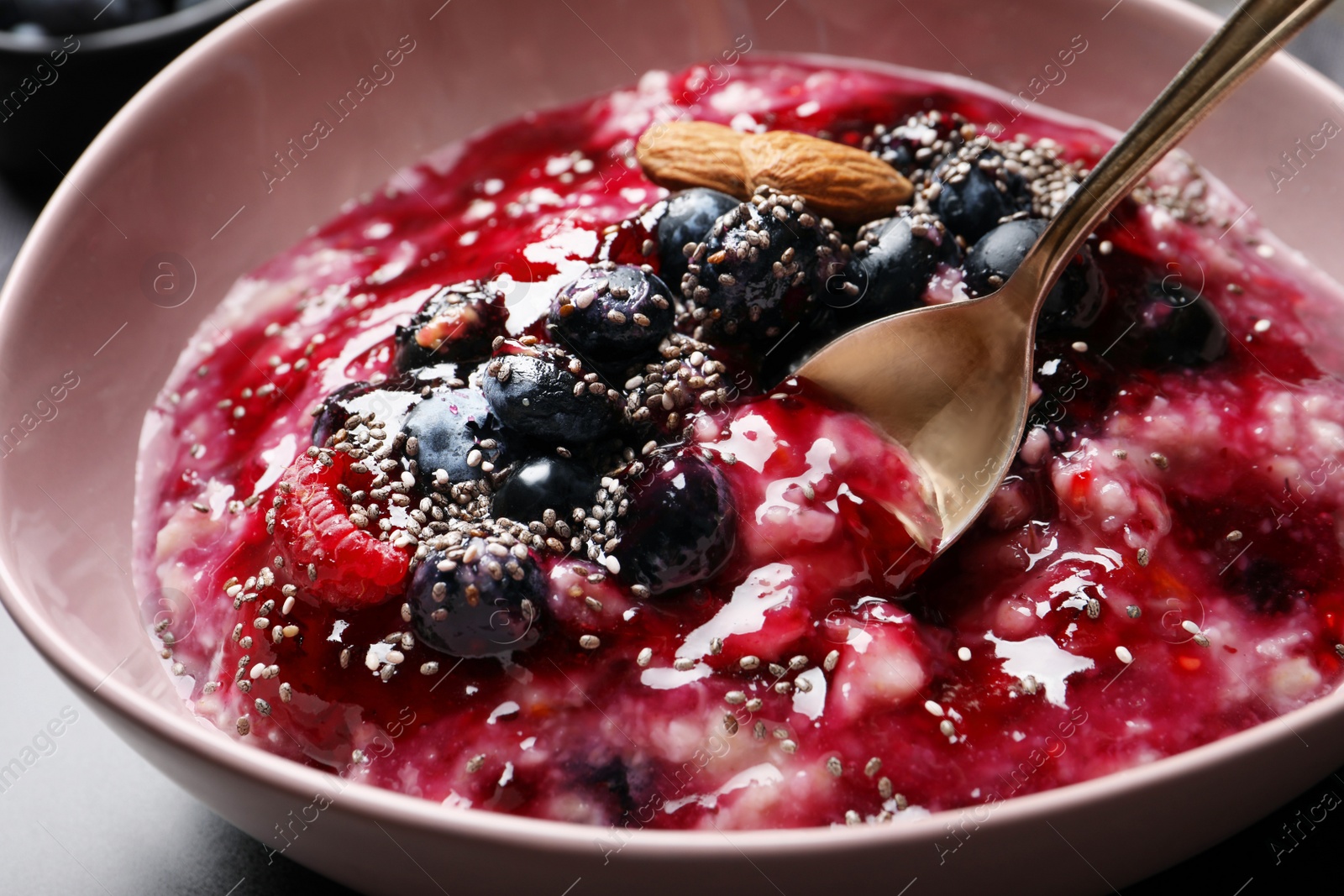 Photo of Tasty oatmeal porridge with toppings on table, closeup