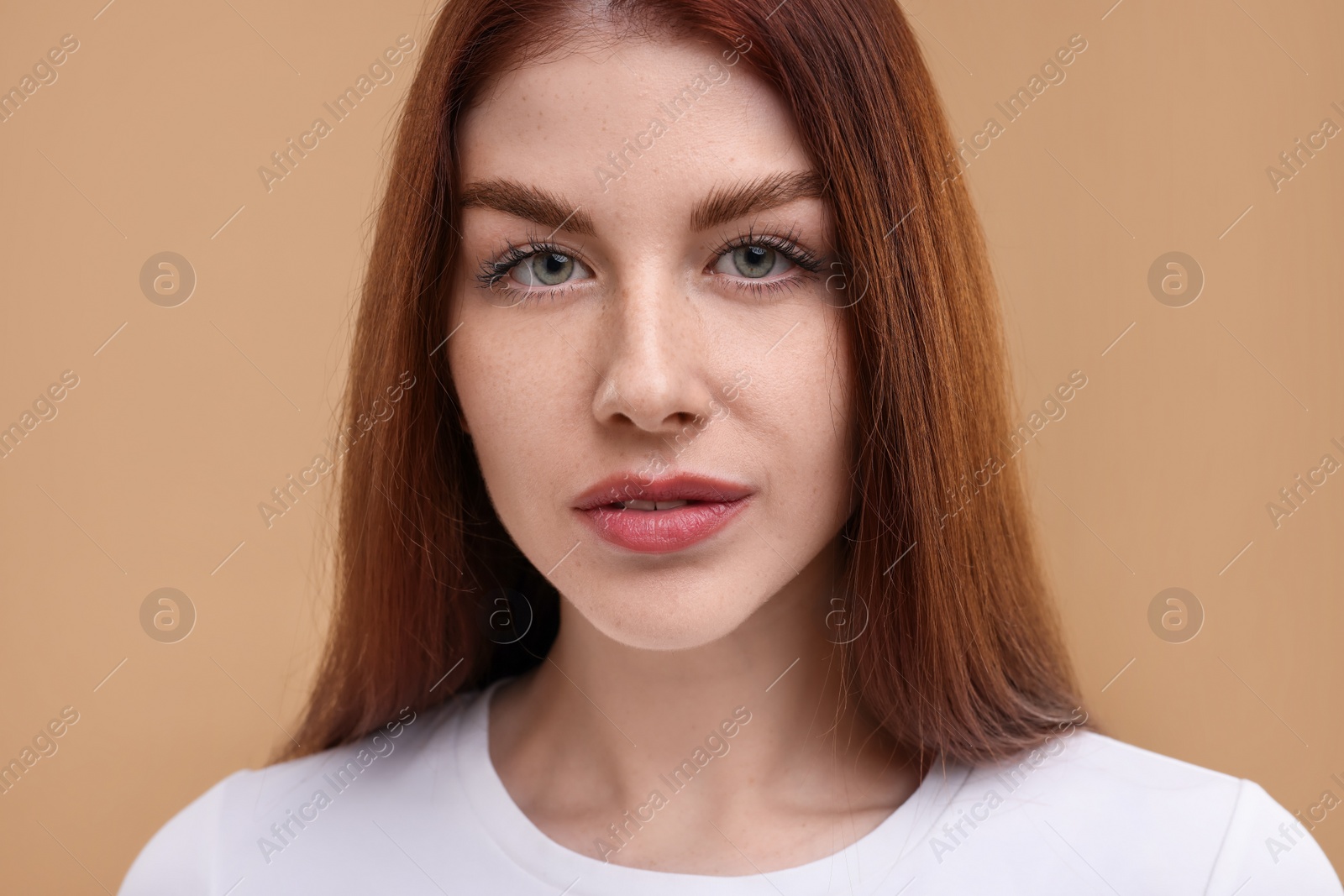 Photo of Portrait of beautiful woman with freckles on beige background, closeup