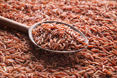 Photo of Pile of brown rice with spoon, closeup, closeup