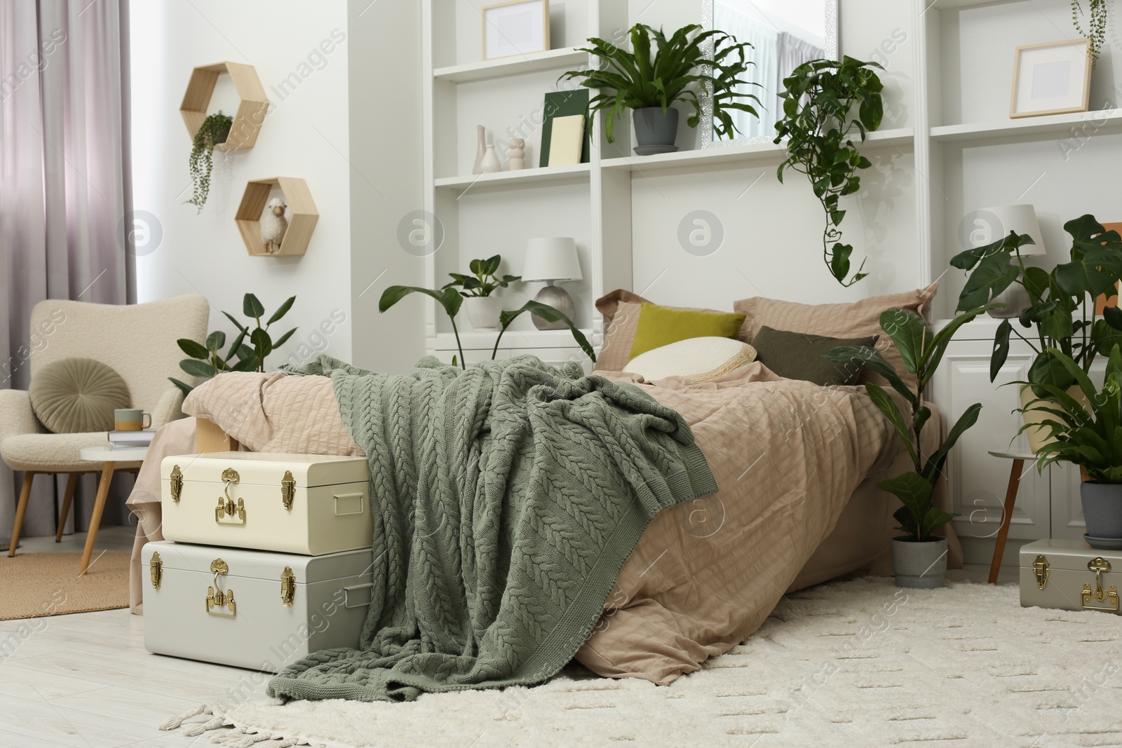 Photo of Stylish bedroom with comfortable bed and different houseplants. Interior design