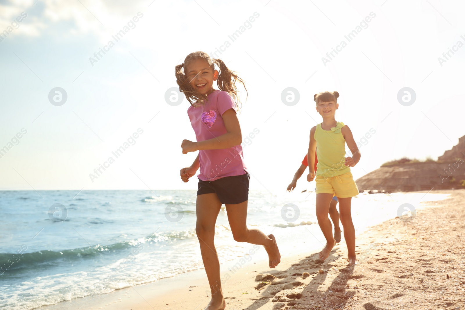 Photo of Cute children enjoying sunny day at beach. Summer camp