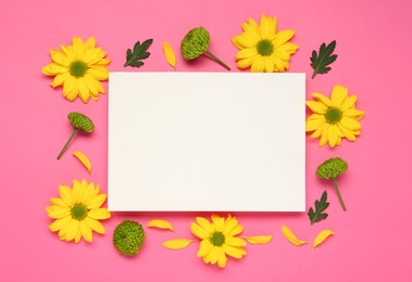 Photo of Beautiful chrysanthemums and blank card on pink background, flat lay. Space for text