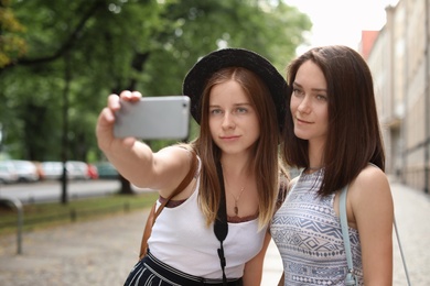 Young women taking selfie on city street