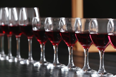 Glasses with delicious red wine on table