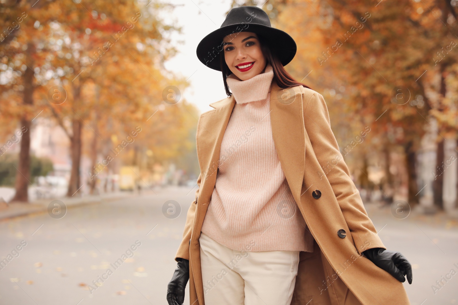 Photo of Young woman wearing stylish clothes on city street, space for text. Autumn look