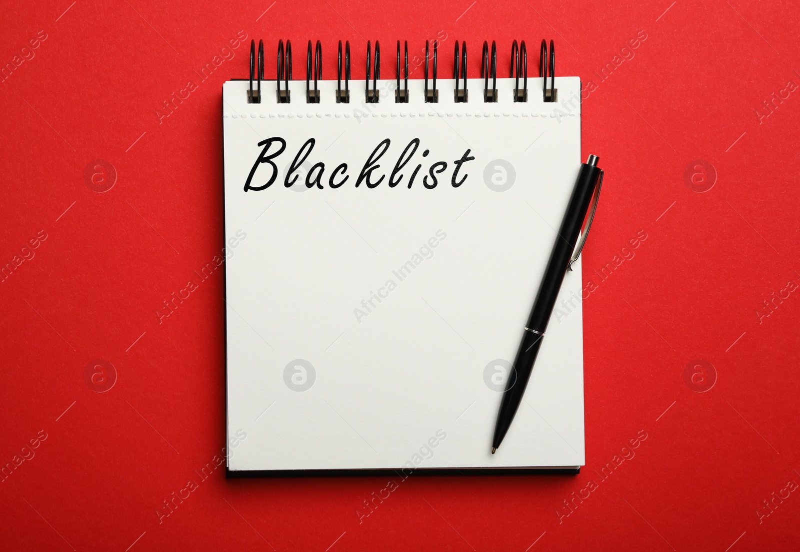 Image of Word Blacklist written in notepad on red background, top view