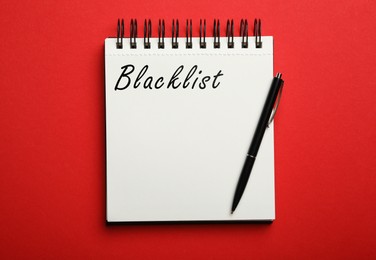 Word Blacklist written in notepad on red background, top view