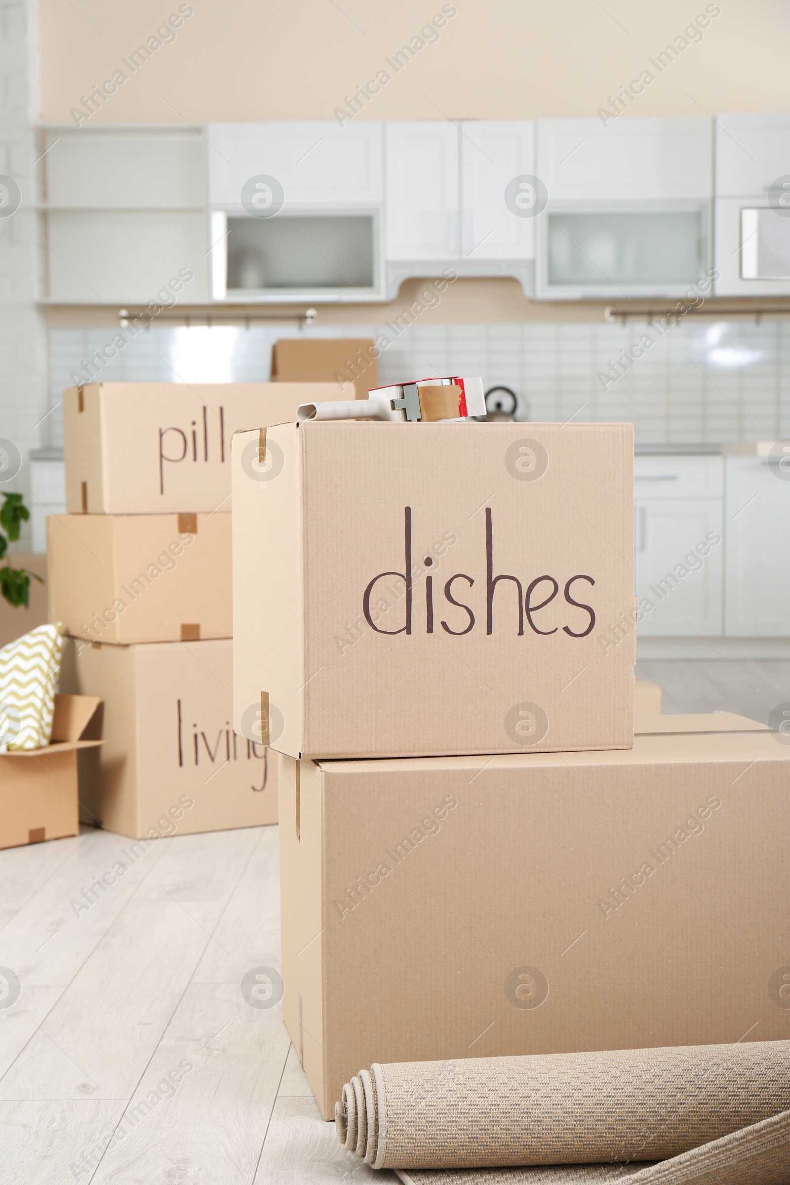 Photo of Cardboard boxes and adhesive tape dispenser in kitchen. Moving day