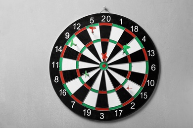 Arrows hitting dart board on grey concrete wall