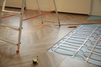 Photo of Installation of electric underfloor heating system indoors