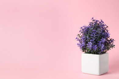 Beautiful artificial plant in flower pot on pink background, space for text