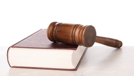 Photo of Wooden gavel and book on light table against white background