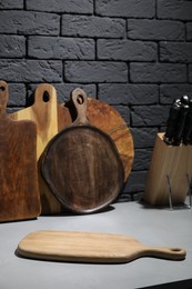 Photo of Wooden cutting boards and knives on gray table