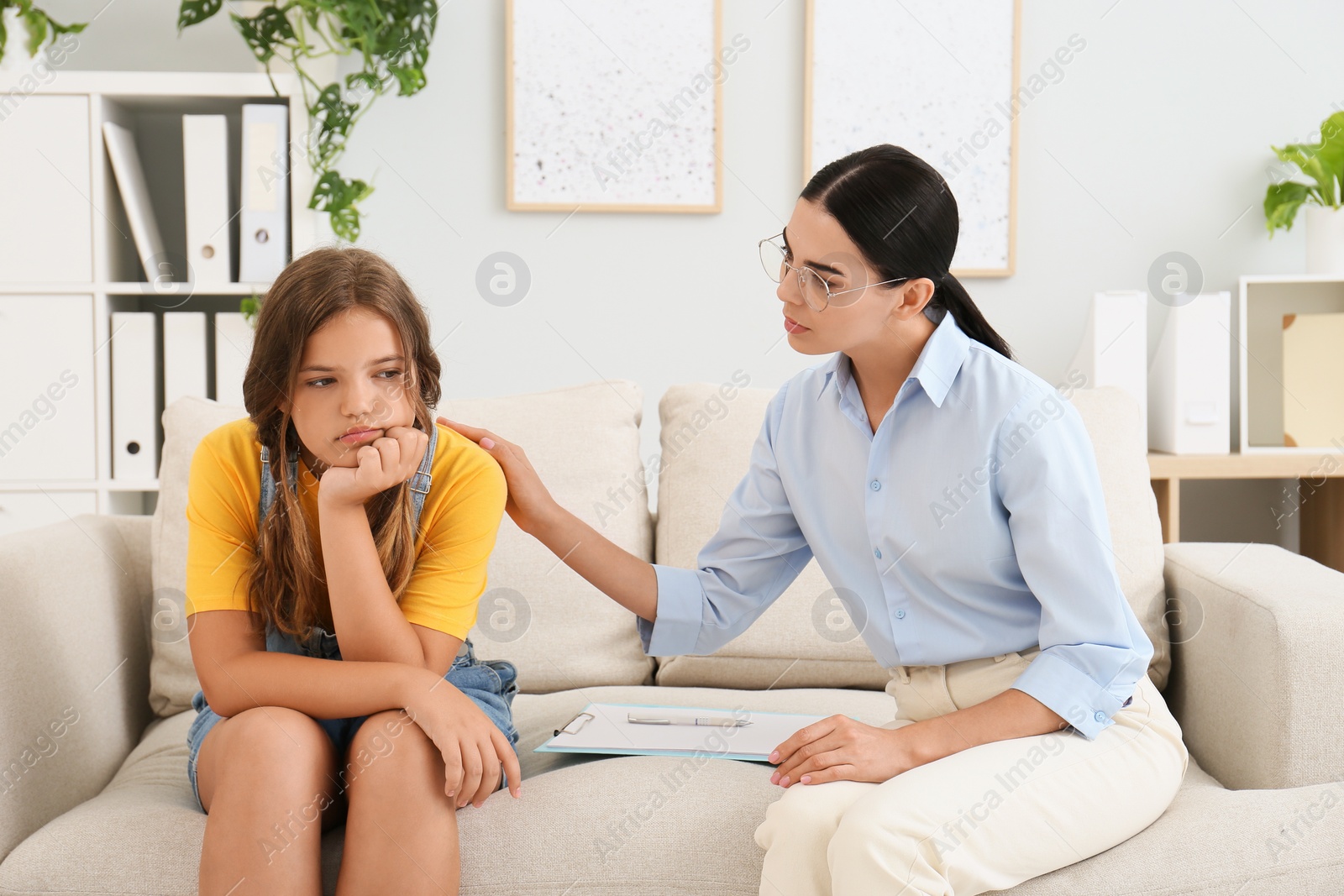 Photo of Young psychologist working with teenage girl in office
