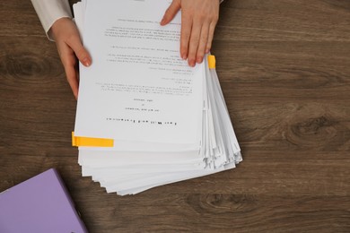 Woman working with documents at wooden table, top view