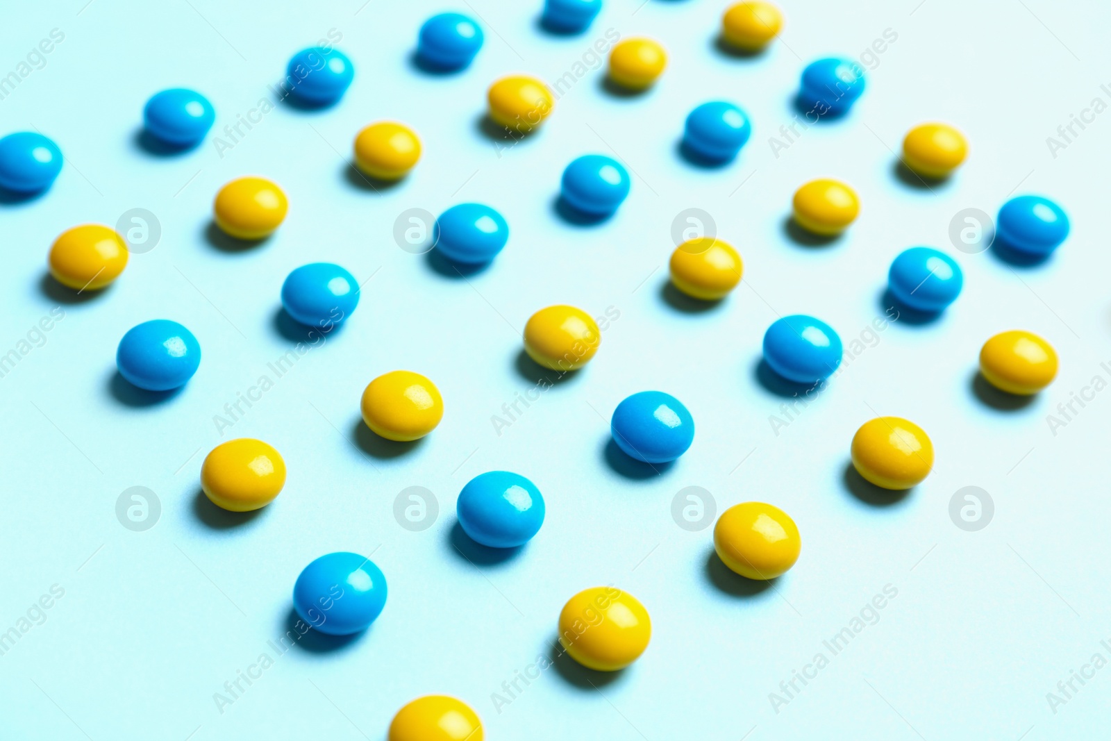 Photo of Delicious bright candies on light blue background