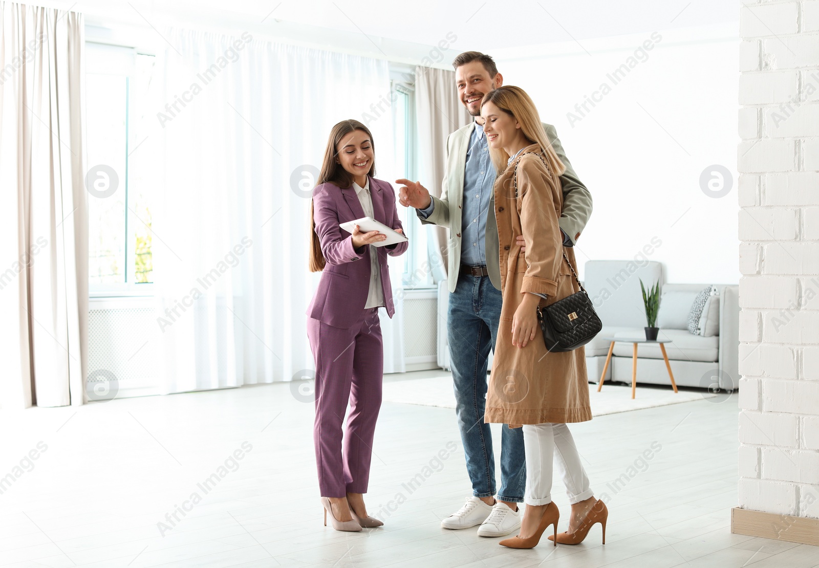 Photo of Female real estate agent working with couple in room