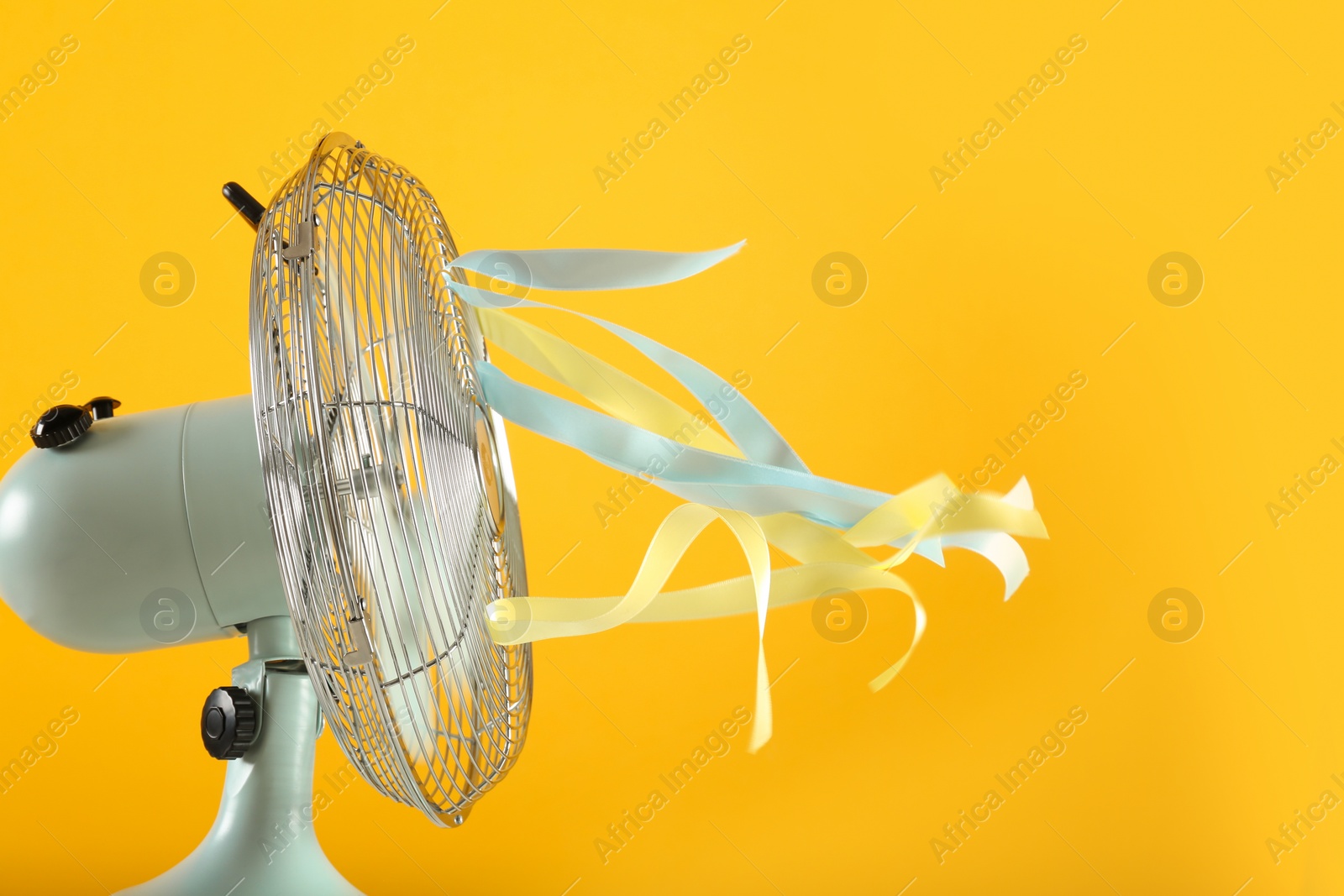 Photo of Electric fan on yellow background. Summer heat