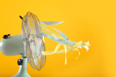 Photo of Electric fan on yellow background. Summer heat