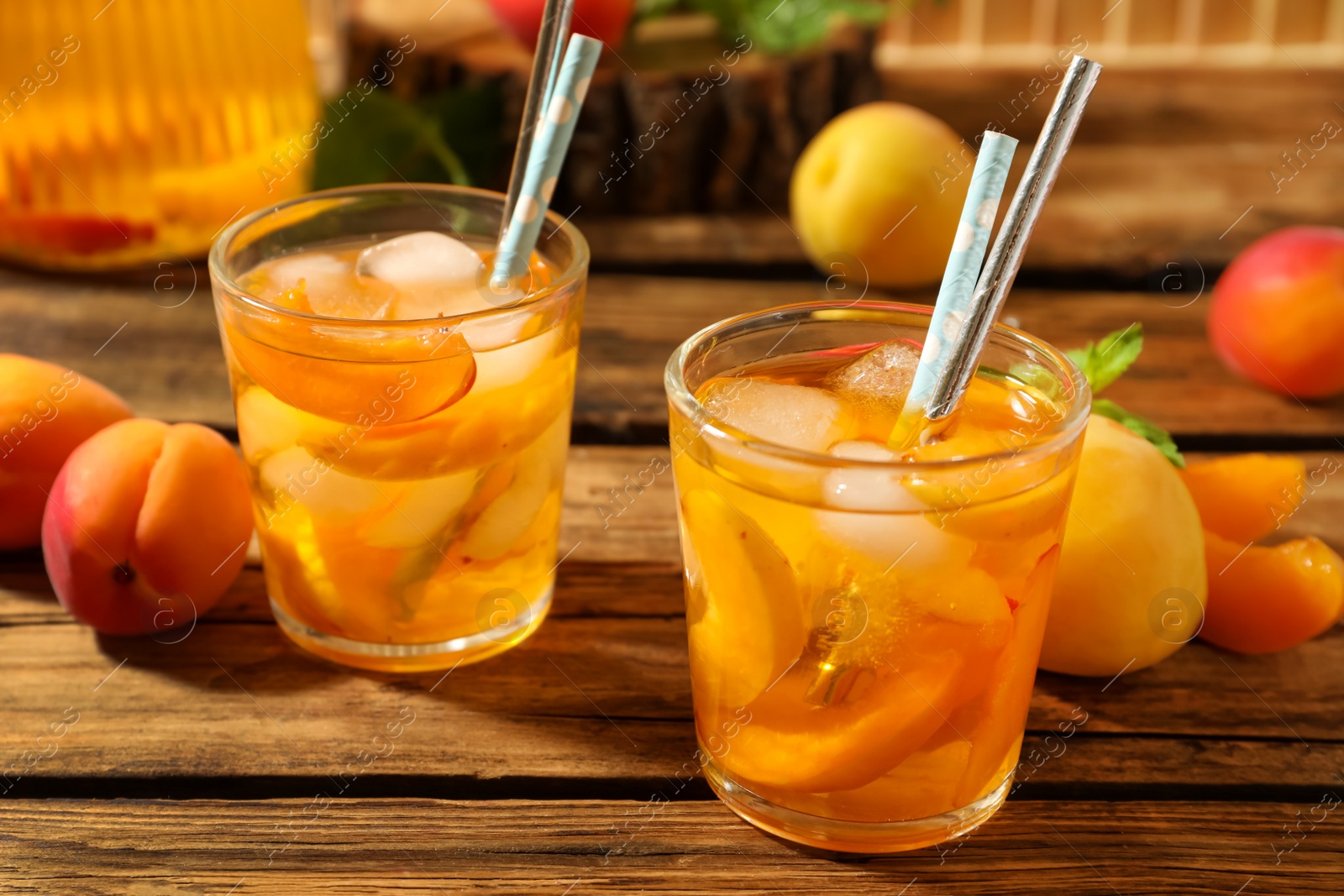 Photo of Delicious refreshing drink with apricot on wooden table, closeup