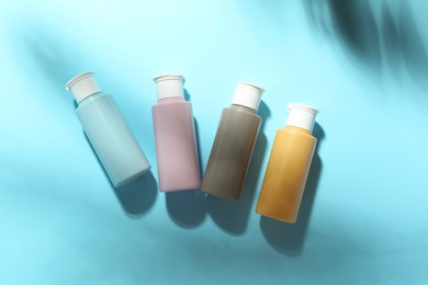 Photo of Cosmetic travel kit on light blue background, top view