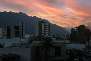 Photo of Picturesque view of city and mountains at sunset