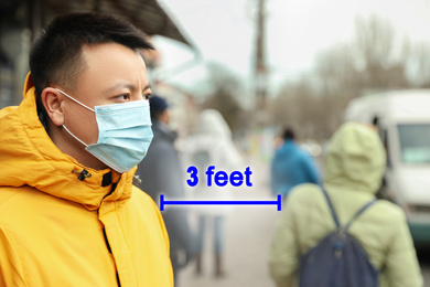 Image of Asian man wearing mask outdoors. Social distancing during coronavirus outbreak