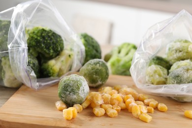 Frozen vegetables on wooden table indoors, closeup