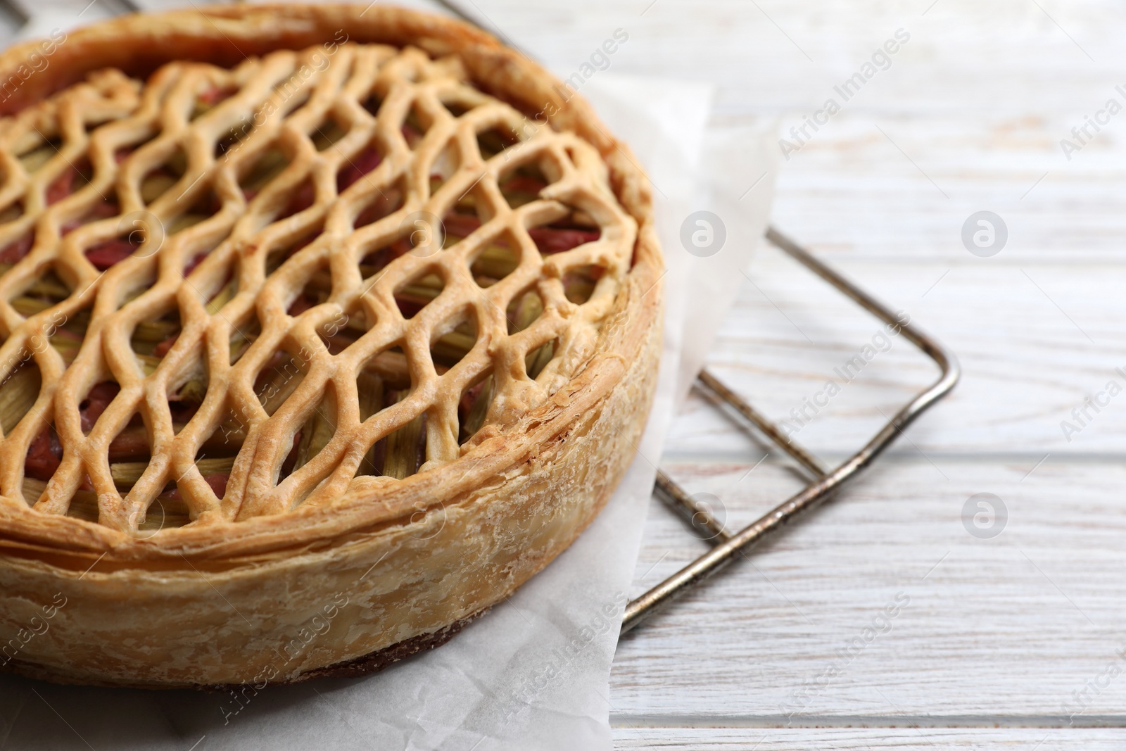Photo of Freshly baked rhubarb pie on light wooden table, closeup. Space for text